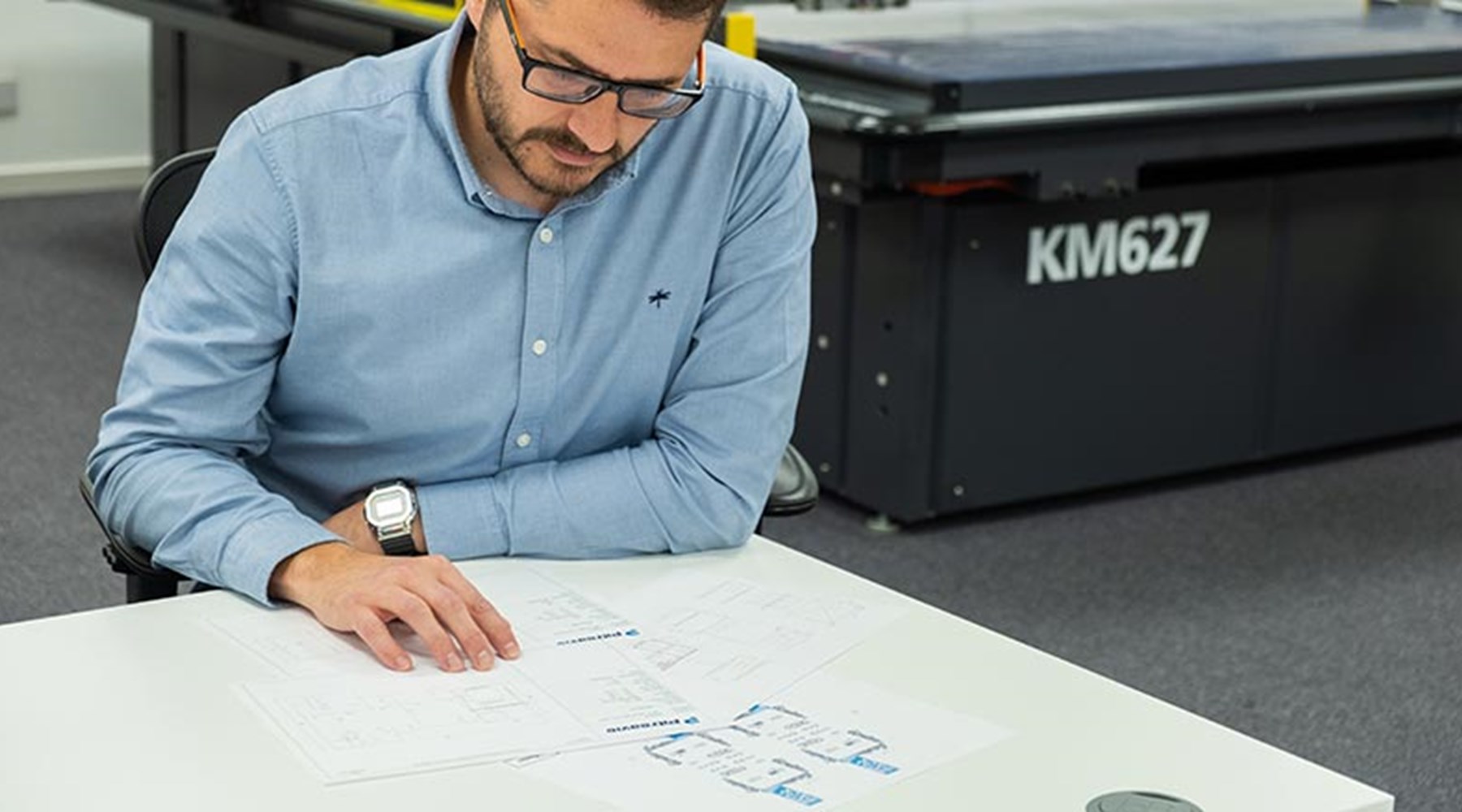 Man looking at structural design blue prints on table
