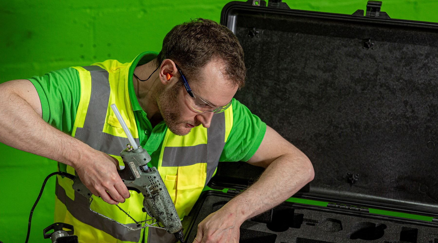 man gluing foam to peli case