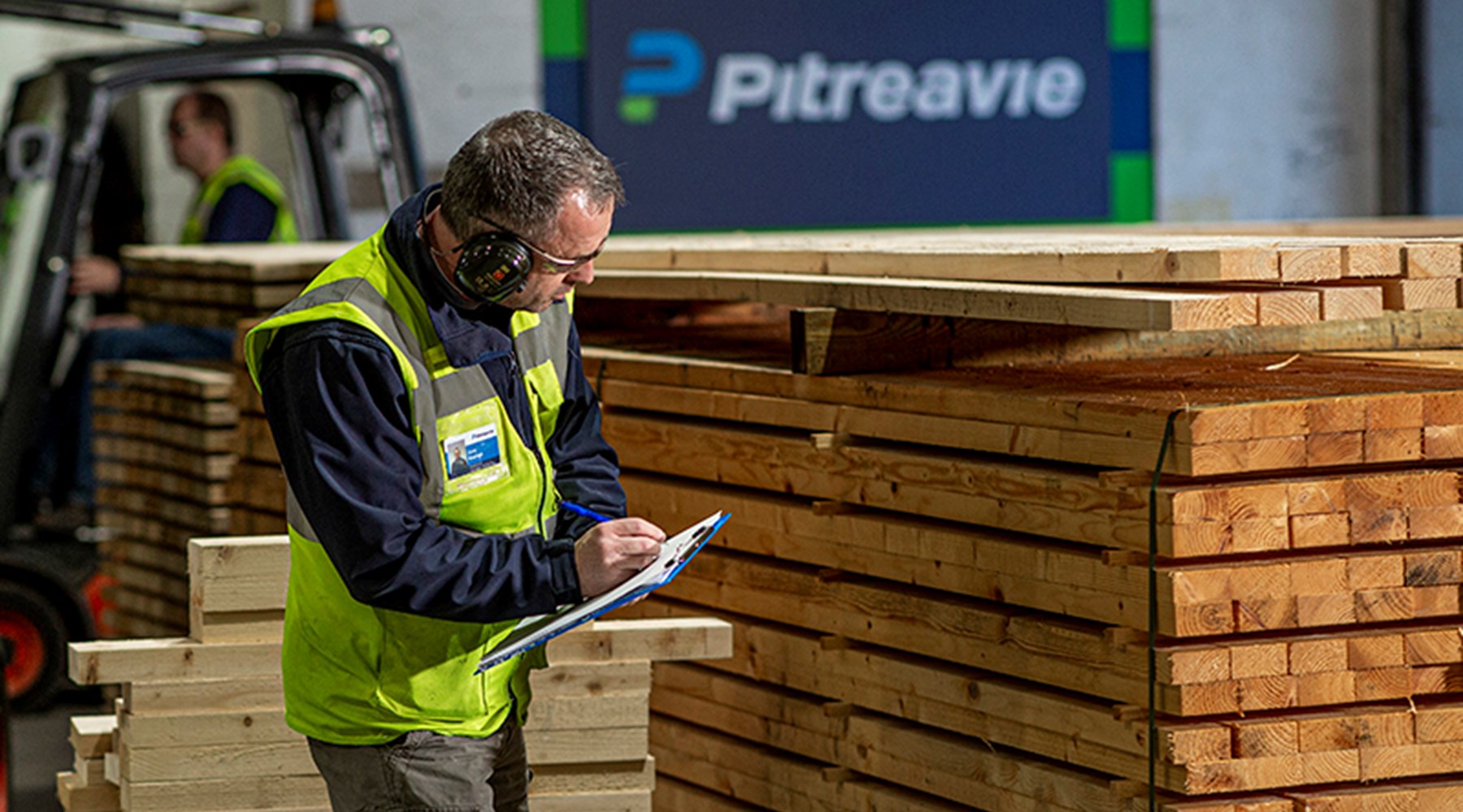 timber and plywood crates man using clipboard to quality check large pile of timber